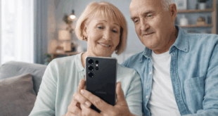 Älteres Ehepaar sitzt auf dem Sofa und nutzt gemeinsam ein modernes Samsung-Smartphone in einer hellen, modernen Wohnumgebung.